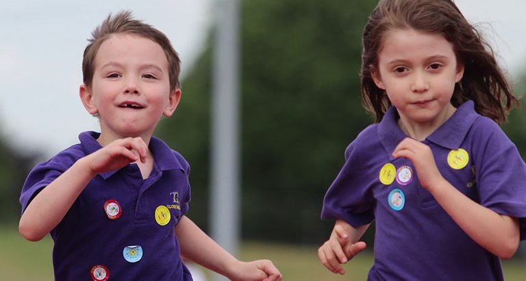 Two Gower School Children Running on a Track.