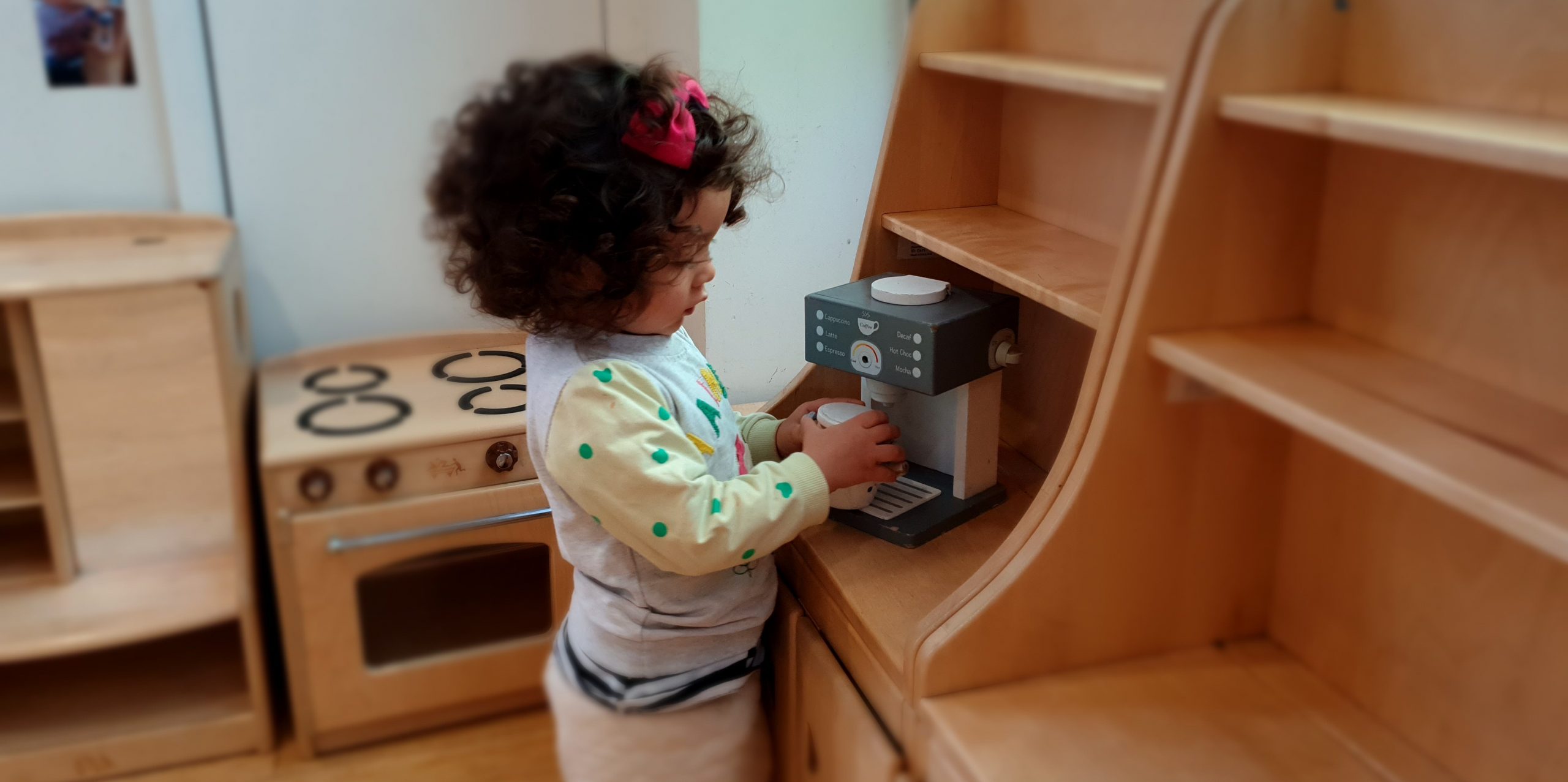 a Child in the Home Corner of the Gower School, a Private Nursery in London.