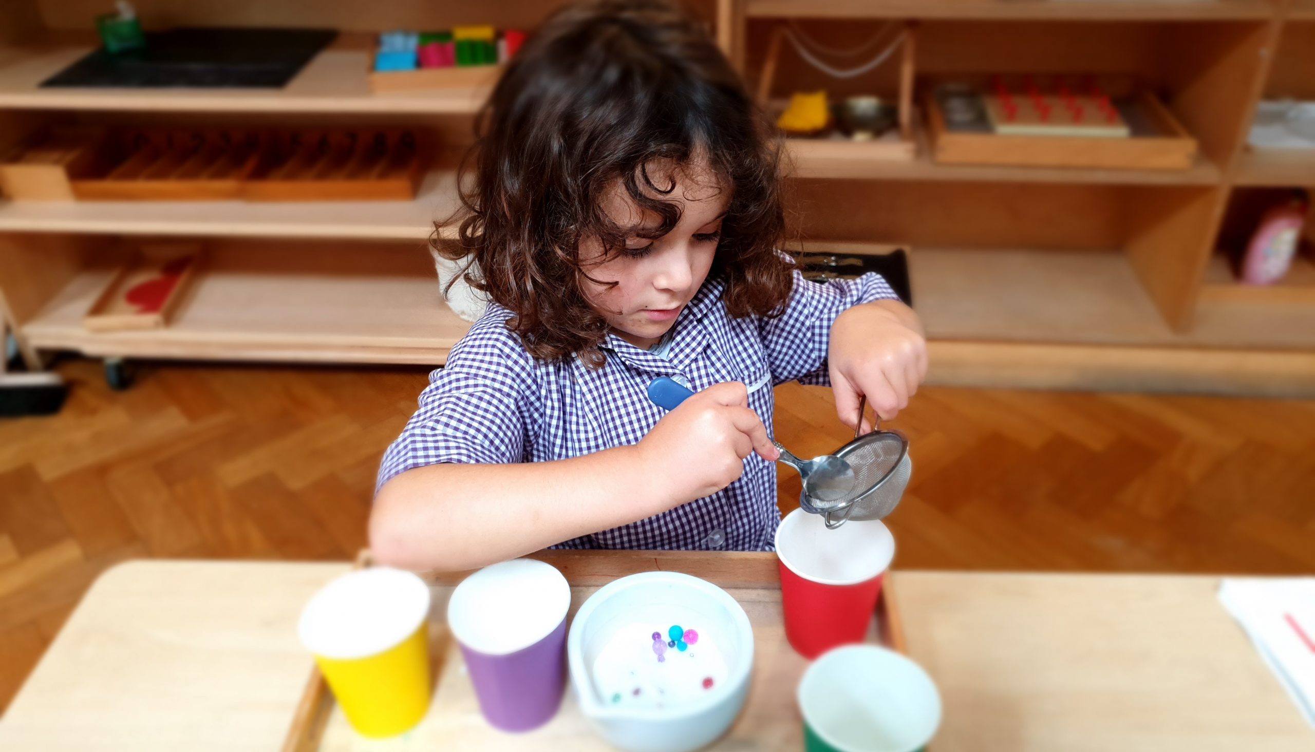 a Focused Child Engages with Transferring Activities in the Gower School's Montessori Nursery in Islington.