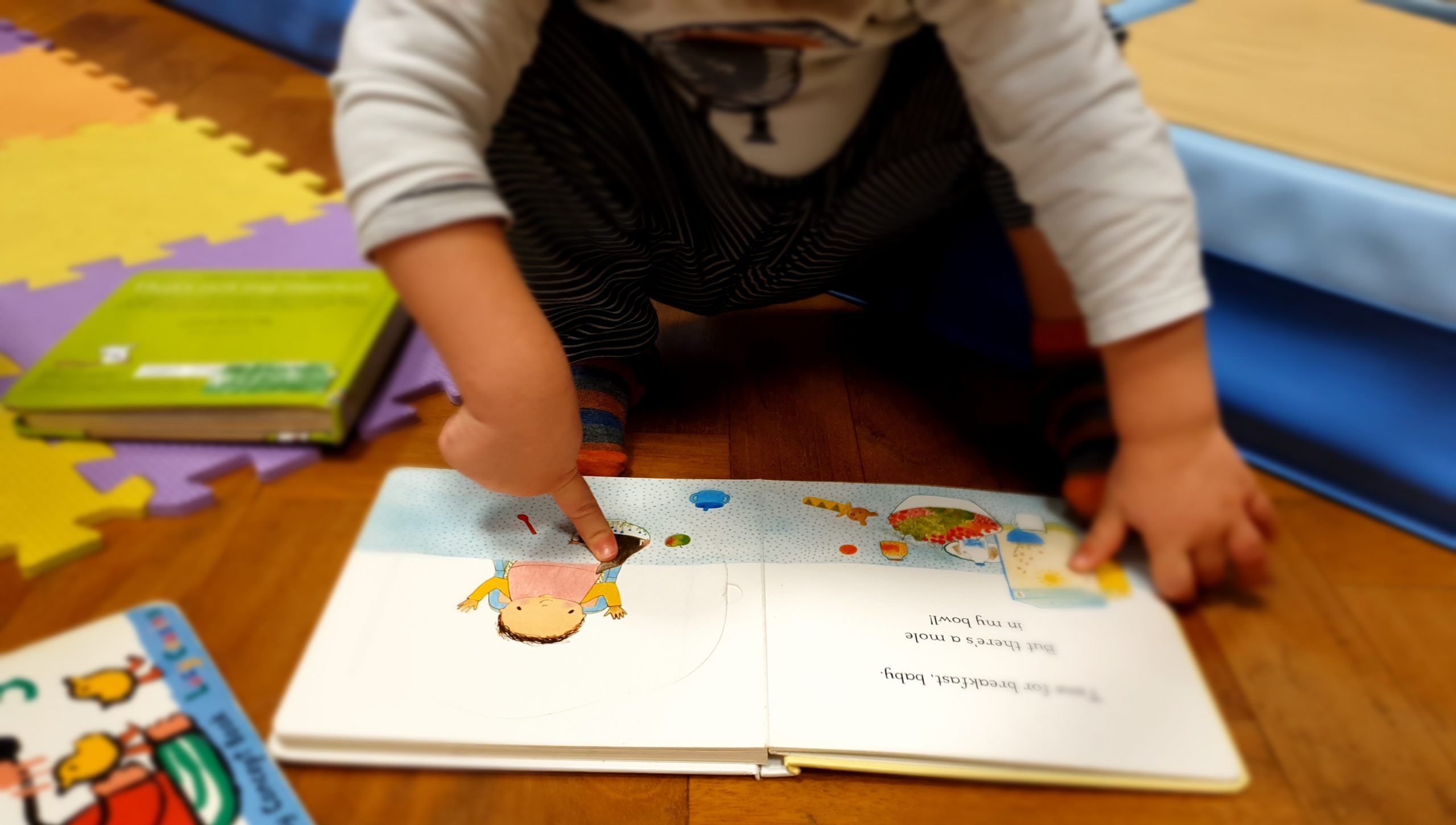 a Toddler Reading a Book at the Gower School Nursery in Islington.