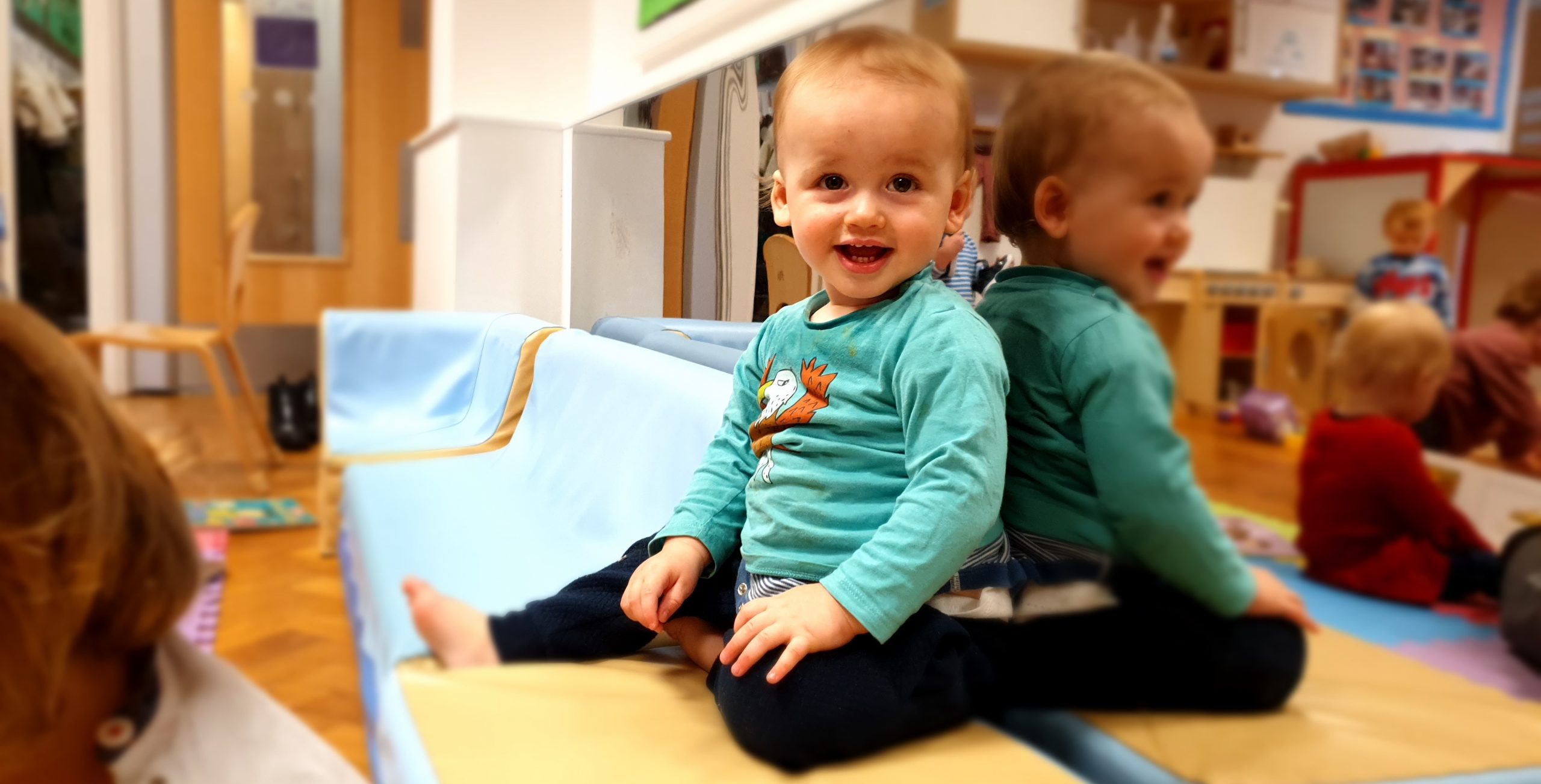 a Smiling Baby Sitting in the Gower School Independent Nursery.