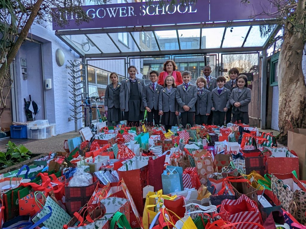 The Gower School Council stands before the sea of donated Christmas gifts.