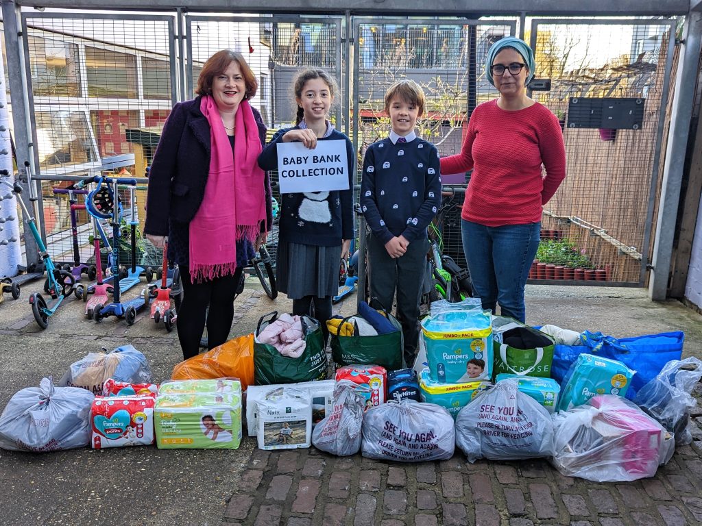 The Gower School Head Boy and Head Girl give donations to FAcT, a baby bank.