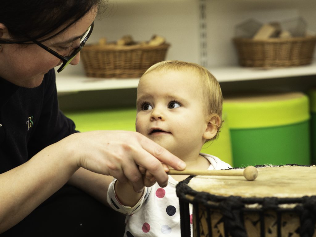 child looking at a drum